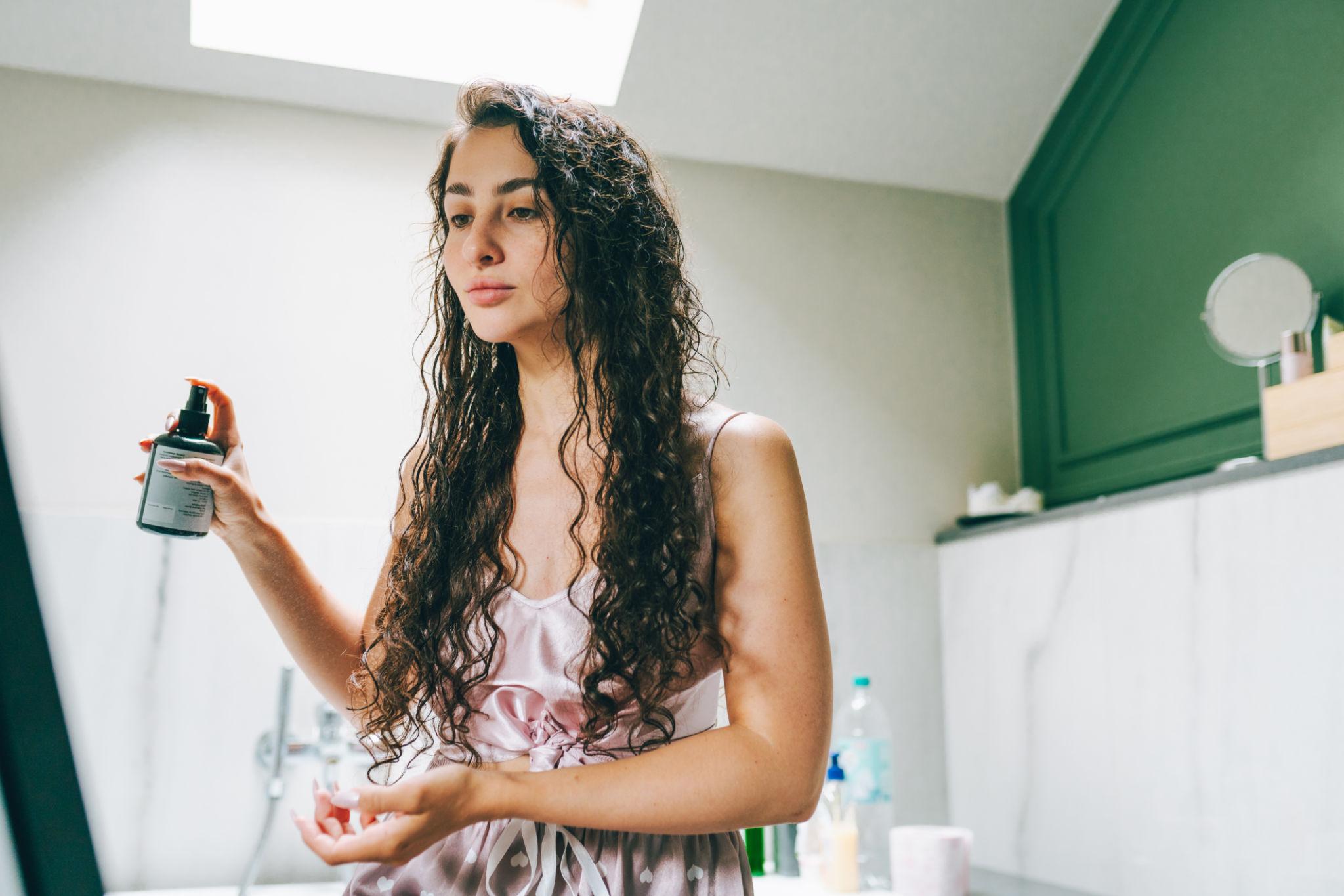 Mulher brasileira com cabelo cacheado natural durante uma rotina premium de cuidados capilares, representando marcas indie focadas em cabelos texturizados e comunidades de haircare