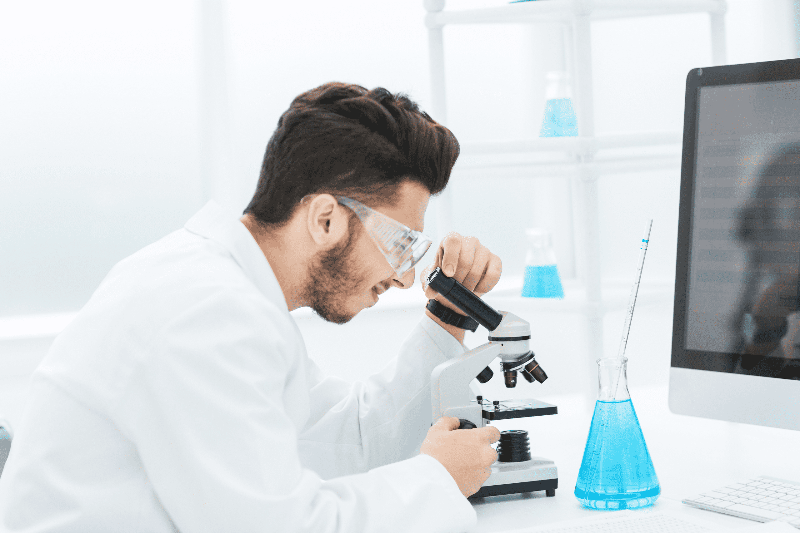 Lab person peeking into a microscope