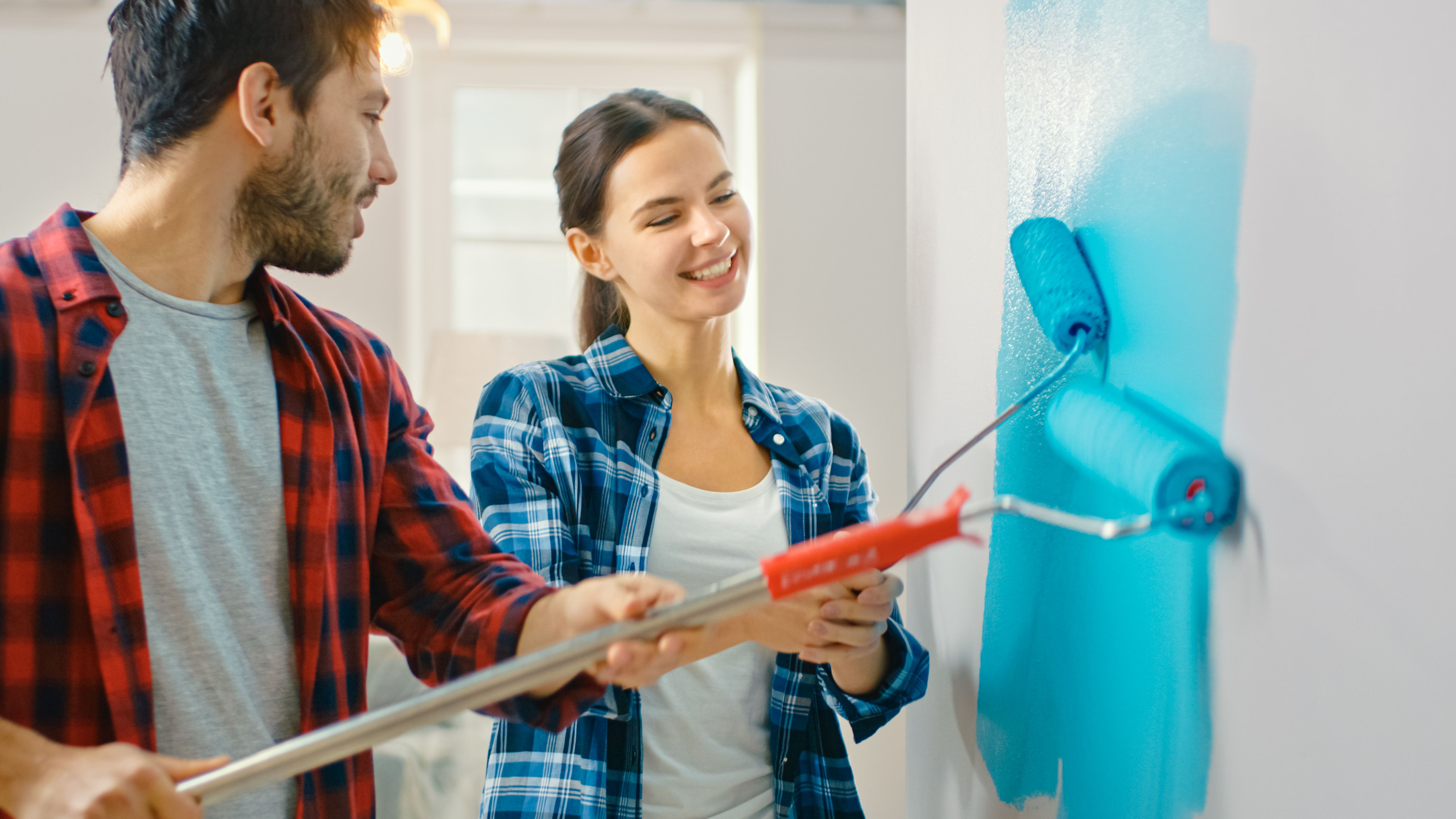 man and a woman painting a wall