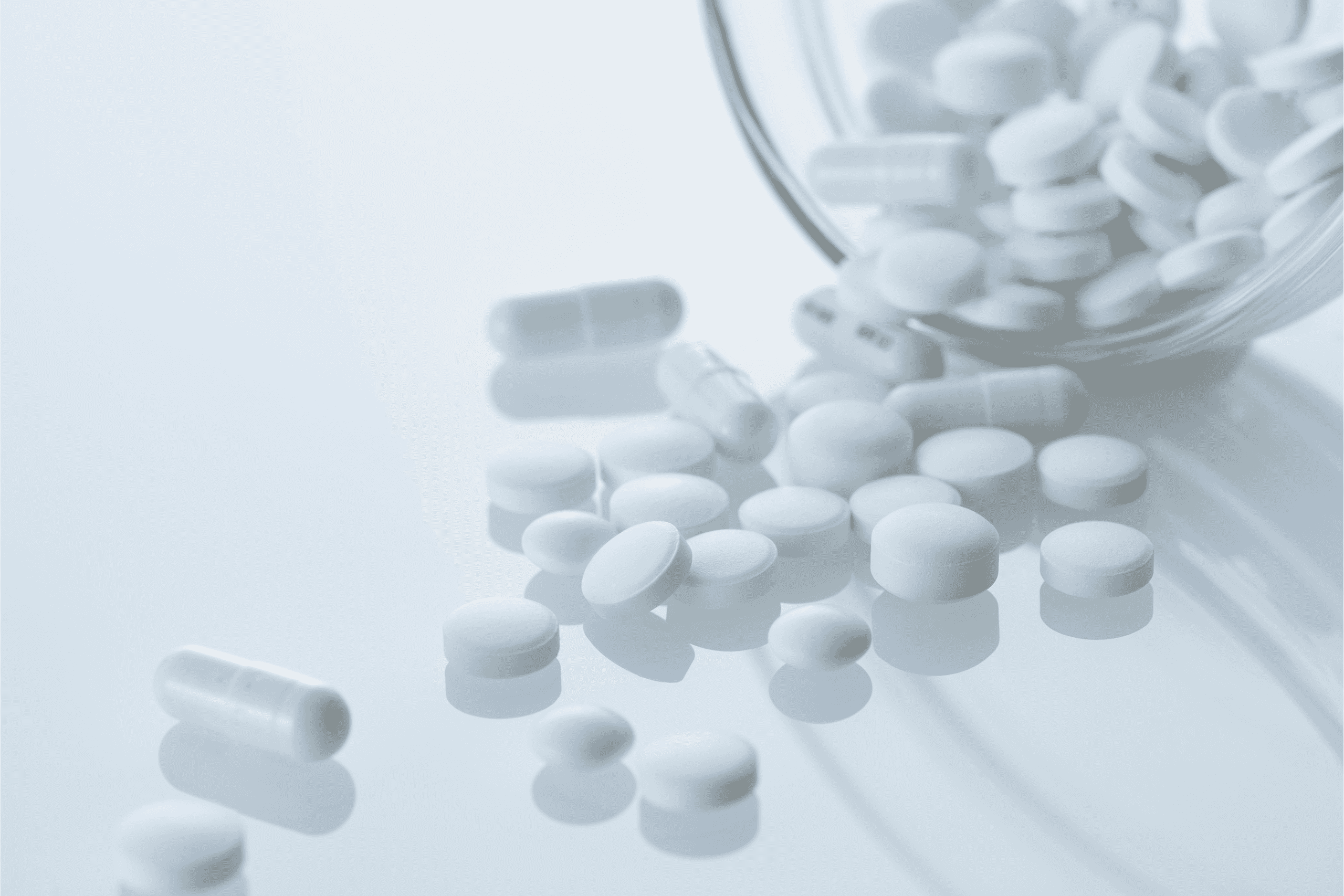 a bunch of white tablets out of a glass