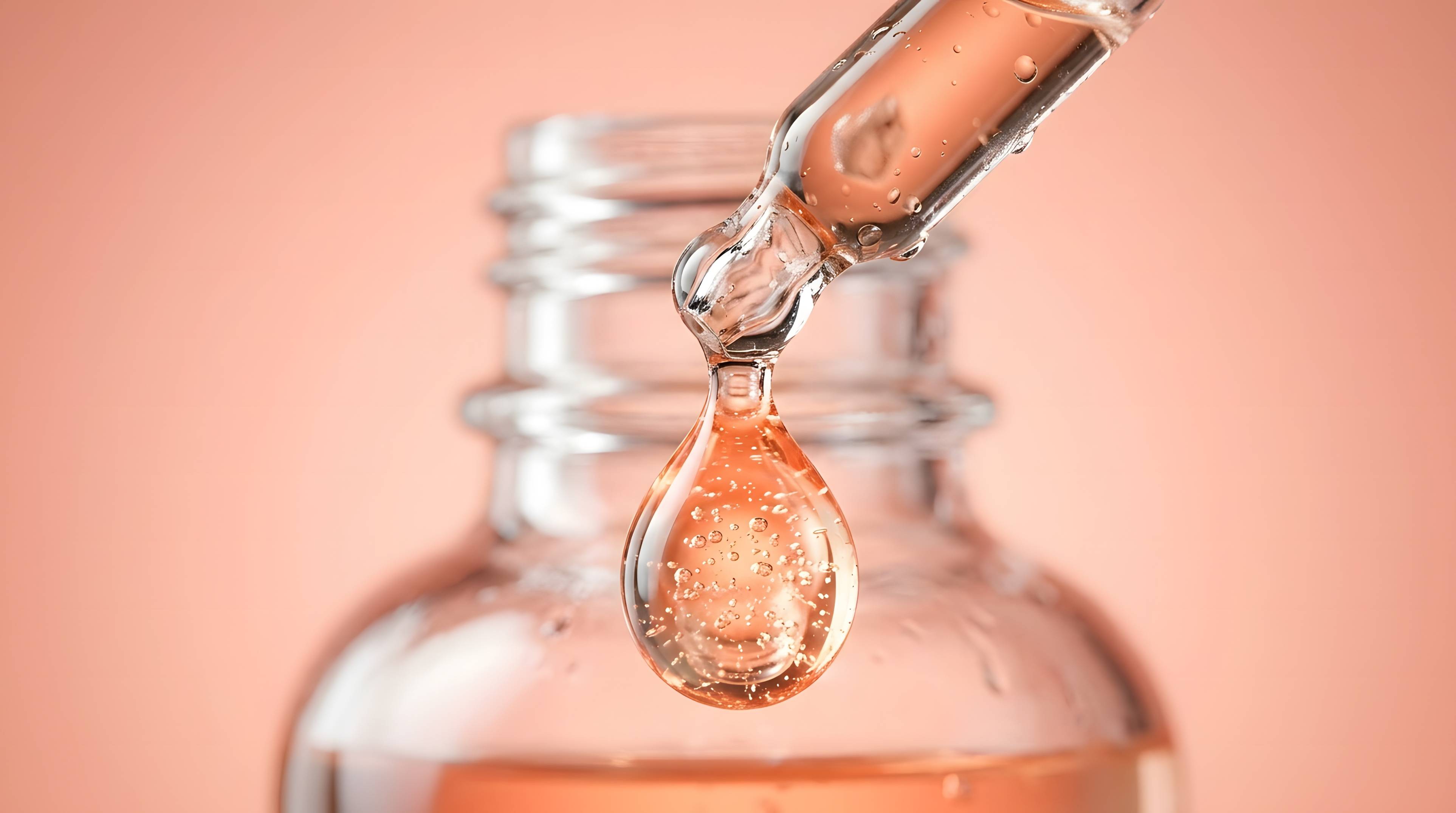 Hydrating hyaluronic acid drop dripping from transparent glass dropper